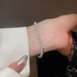 Detailed close-up of beaded bracelet with white pearls and sparkling pavé crystal spheres