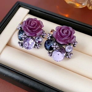 Macro shot of luxury vintage purple rose earrings with multicolored crystals on a jewelry box
