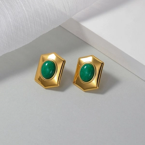 Vintage 18K gold hexagon stud earrings with green oval stone on a white display