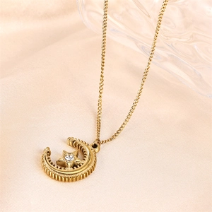 Close-up of golden moon and star pendant necklace with cubic zirconia on beige silk