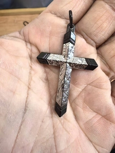Gros plan du pendentif croix en acier inoxydable argent et noir au style punk