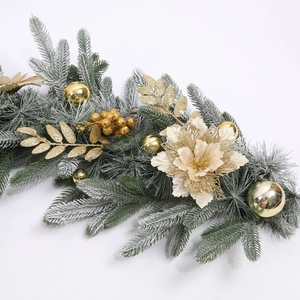 Detailed view of snowy Christmas garland with golden flowers and glittery ornaments