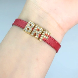 Red leather wristband with gold-plated BFF rhinestone letter charms on a model wrist