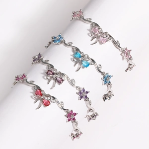Detail of silver bracelets with colorful zircon butterfly and floral motifs in four colors