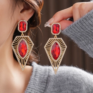 Detailed close-up of vintage geometric earrings with red gemstones and gold plating