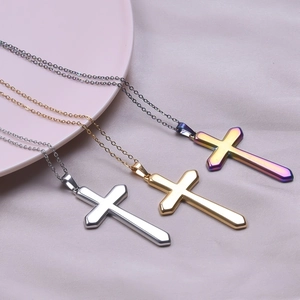 Three minimalist stainless steel cross necklaces in silver, gold, and purple gradient