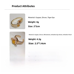 Detail of gold snake-shaped rings showing zircon, tiger eye stone, and pearl materials