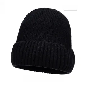 Detailed close-up of a black ribbed knit beanie with a brown leather snowflake patch