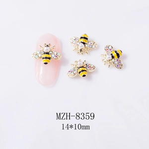 Close-up of cute 3D bee nail charms with colorful rhinestones and pearl detail