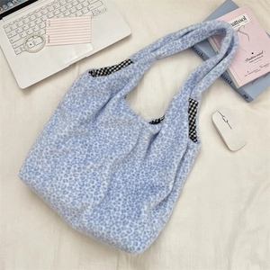 Detailed view of plush leopard print tote bag with stylish blue pattern and plaid lining