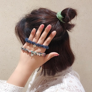 Élastiques à cheveux perlés élégants en vert et bleu marine, portés comme bijoux de poignet