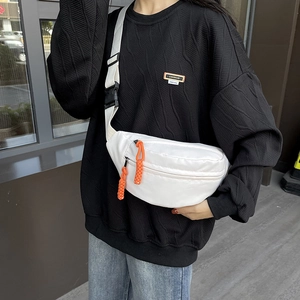 Minimalist white canvas chest bag for women with orange zipper detail and adjustable strap