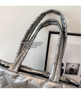 Détail du sac cabas matelassé argenté montrant les longues anses et les coutures en losange