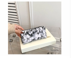 Detail of long lady's purse with marble pattern texture and gold zipper closure
