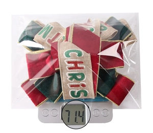 Detailed view of 71.4g Christmas tree bow decoration with velvet fabric on scale