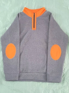 Détail d'un sweat gris avec coudières orange et col montant à fermeture éclair