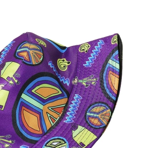 Close-up of a purple bucket hat featuring peace signs and colorful graffiti print