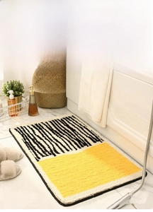 Detail view of absorbent bathroom rug with yellow blocks and black striped texture