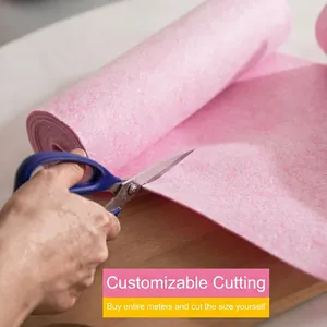 Pink coconut fiber cleaning cloth roll being cut by scissors on a wooden table