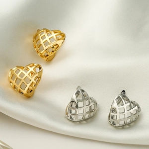 Minimalist gold and silver hollow heart earrings on white silk background