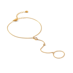 Minimalist gold slave bracelet with three sparkling zircons on a white background