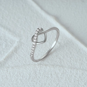 Macro shot of silver S925 heart ring with crisscross pavé set cubic zirconia stones