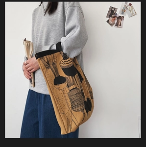Close-up of mustard yellow canvas tote bag with vegetable print and black handles