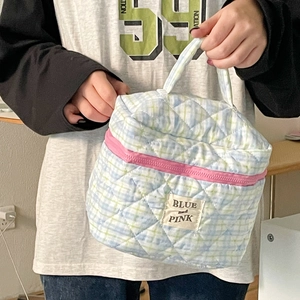 Quilted cotton makeup bag with plaid pattern and pink zipper held by hand
