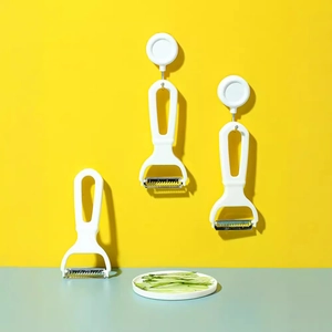 Japanese style vegetable peeler set with white plastic handles on a yellow background