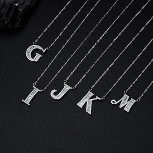 Silver letter pendants necklaces with sparkling zircon inlay on black background