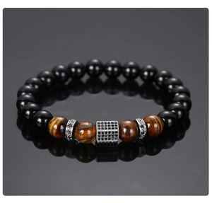 Macro view of matte black beads and tiger eye stone bracelet with zircon hexagonal charm