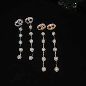 Detail of tassel earrings featuring zircon hollow studs and elegant white pearls
