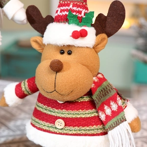 Detailed close-up of a plush Christmas reindeer toy featuring red and green striped knitwear