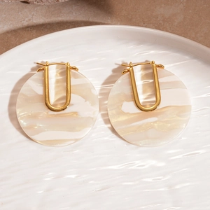 Detail of 18k gold plated U-shaped earrings with marble pattern acetate texture