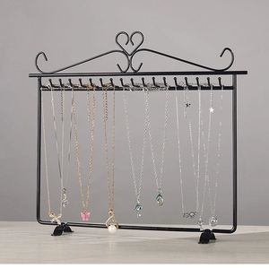 Detail of black iron wall-mounted necklace organizer with 20 hooks and heart design