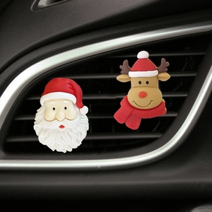 Detail of Santa Claus and reindeer car air vent clips installed on a vehicle outlet