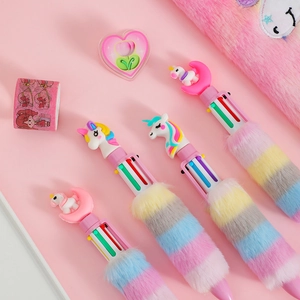 Flat lay of pink unicorn stationery set with plush multi-color pens and washi tape