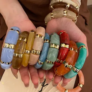Colorful resin acrylic cylinder bead bracelets with gold metal spacers on model