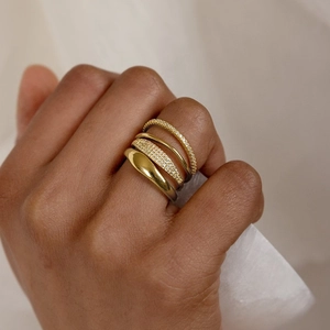 Macro shot of four stacked gold rings with cubic zirconia inlay and polished finish