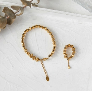 Detailed macro view of 18K gold plated beaded bracelet and ring set with K18 stamp