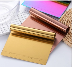 Detail of stainless steel dough scrapers in gold, rose gold and rainbow finishes with scale