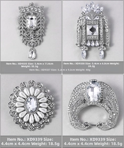 Detailed view of four vintage rhinestone brooches with silver finish and pearl accents
