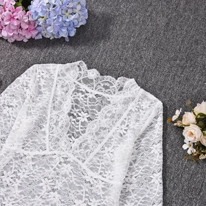Close-up of white floral lace pattern and V-neckline detail on a long sleeve top