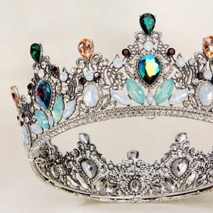 Macro detail of silver baroque crown with multicolored gemstones and waterdrop crystals