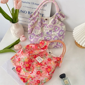 Detailed shot of floral canvas tote bags with rope handles and rustic fabric labels