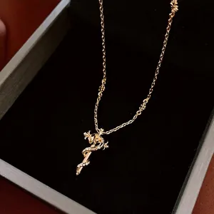 Vintage gold snake cross pendant necklace with zircon inlay on a black velvet box