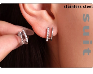 Macro view of double-layered silver U-shape earrings with zircon studs on ear