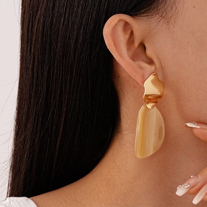Vue détaillée de boucles d'oreilles irrégulières en métal doré avec pendentif acrylique