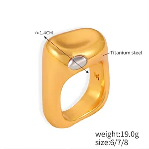 Vue macro d'une bague en acier titane doré de 1,4 cm avec insert argenté et gravure M