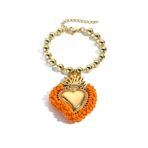 Handgefertigtes Perlenarmband mit goldenen Metallperlen und orangefarbenem Herzanhänger